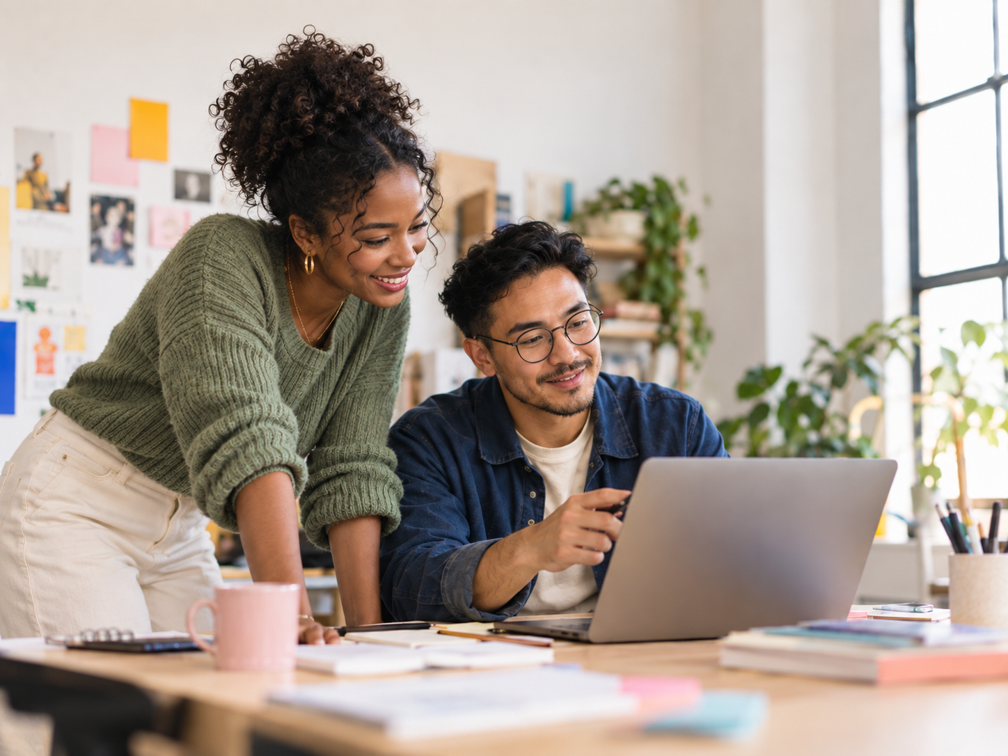 Two agency teammates reviewing creative work together on a laptop